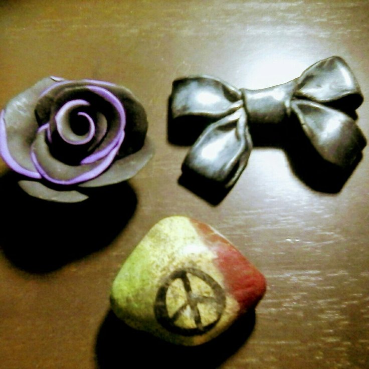 This is a clay purple and black rose, use to have leaves- they fell off. Then a simple shimmer black bow made of clay. And last a rock that I had found and decided to paint. 